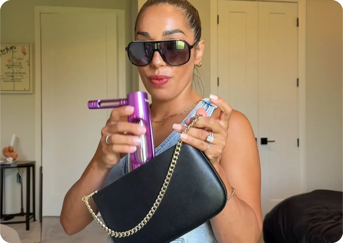 Woman holding a purple ZenPuff above a black handbag